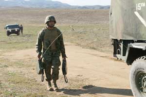 Soldier carrying electonic equipment to a truck